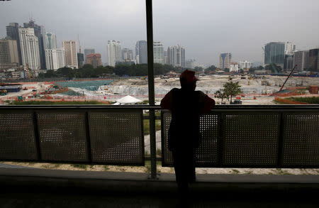 FILE PHOTO: A man looks out at the 1 Malaysia Development Berhad (1MDB) flagship Tun Razak Exchange development in Kuala Lumpur, Malaysia, July 3, 2015. REUTERS/Olivia Harris/File Photo