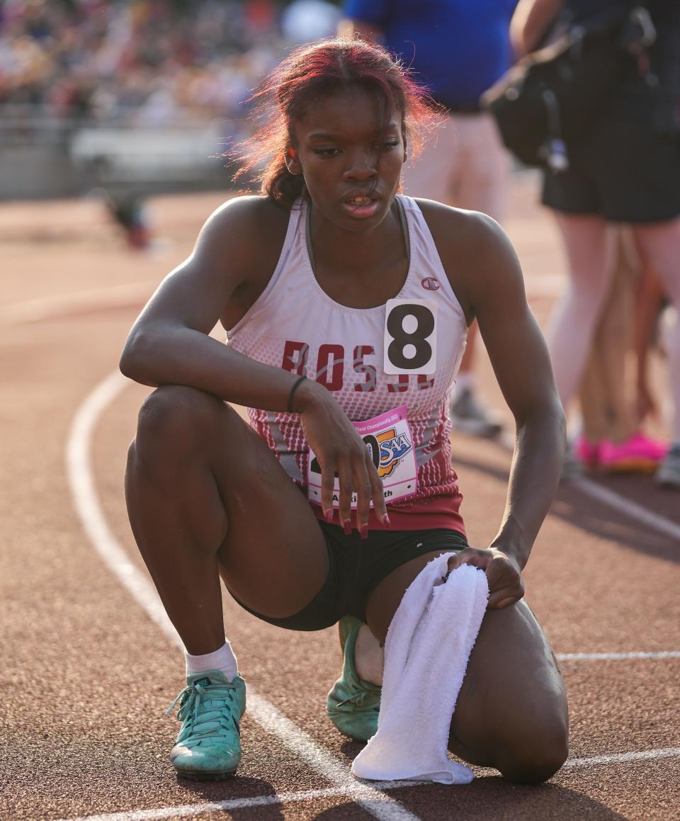 Evansville Bosse's Alexia Smith kneels down to breathe after winning the 400 meter race Saturday, June 3, 2023, during the IHSAA girls track and field state finals at Robert C. Haugh Track and Field Complex at Indiana University in Bloomington. 