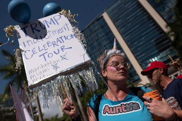 An anti-Trump demonstrator in front of the Miami courthouse holds a sign reading, 