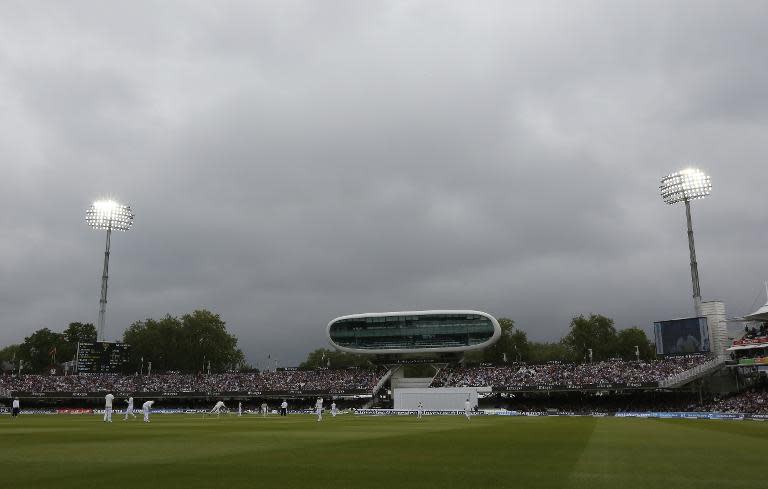 Floodlights are switched on as dark clouds appear during play on the third day of the first Test between England and New Zealand at Lord's on May 23, 2015