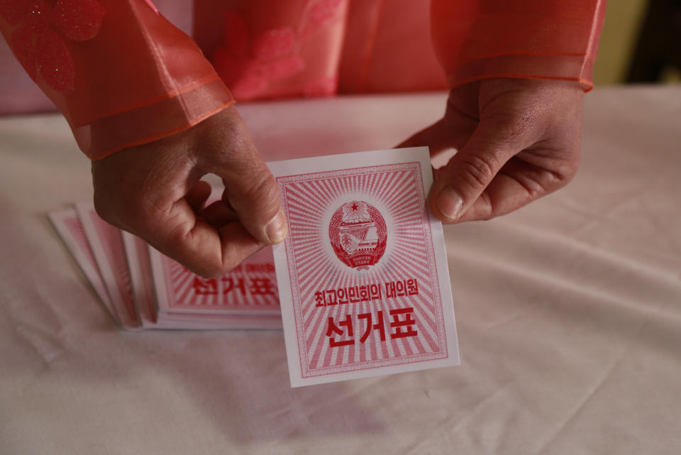 An electoral worker shows a ballot during the election at a polling station in Pyongyang, North Korea, Sunday, March 10, 2019. Millions of North Korean voters, including leader Kim Jong Un, are going to the polls to elect roughly 700 members to the national legislature. In typical North Korean style, voters are presented with just one state-sanctioned candidate per district and they cast ballots to show their approval or, very rarely, disapproval. (AP Photo/Dita Alangkara)