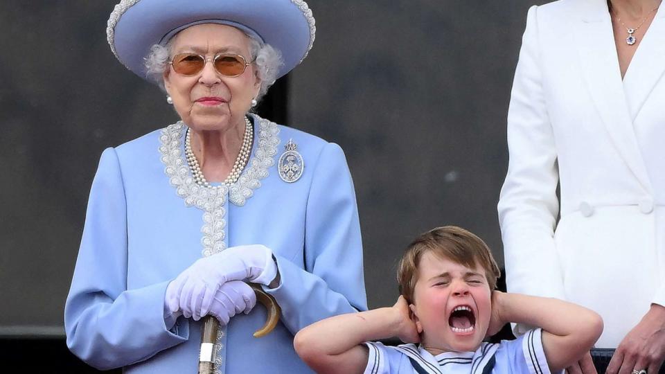 PHOTO: Britain's Prince Louis of Cambridge holds his ears as he stands next to Queen Elizabeth II to watch a flypast from Buckingham Palace balcony, as part of Queen Elizabeth II's platinum jubilee celebrations, in London, June 2, 2022. (Daniel Leal/AFP via Getty Images)