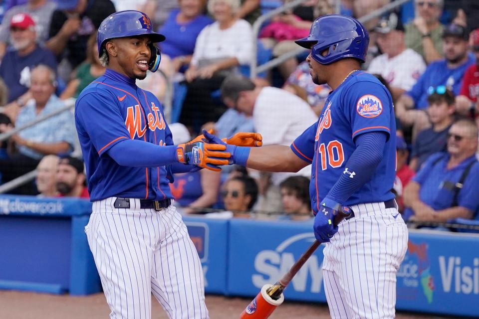 New York Mets' Francisco Lindor, left, is greeted by Eduardo Escobar (10) after hitting a home run during the first inning of the team's spring training baseball game against the Miami Marlins, Thursday, March 24, 2022, in Port St. Lucie, Fla. (AP Photo/Sue Ogrocki)