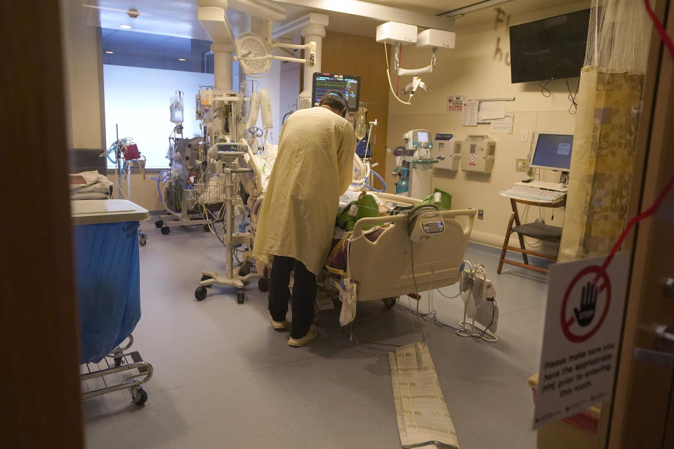 Clinical nurse Zachary Petterson tends to a COVID-19 patient in the intensive care unit at Santa Clara Valley Medical Center during the coronavirus pandemic in San Jose, Calif., Wednesday, Jan. 13, 2021. (AP Photo/Jeff Chiu)