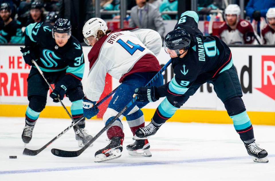 Seattle Kraken center Ryan Donato (9) tries to steal the puck from Colorado Avalanche defenseman Bowen Byram (4) during the first period of a first round 2023 Stanley Cup Playoffs game against the Colorado Avalanches at Climate Pledge Arena in Seattle on Saturday, April 22, 2023.