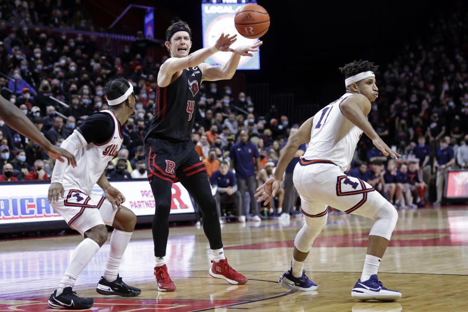 Rutgers guard Paul Mulcahy (4) passes the ball past Illinois guard Trent Frazier during the second half of an NCAA college basketball game Wednesday, Feb. 16, 2022, in Piscataway, N.J. (AP Photo/Adam Hunger)