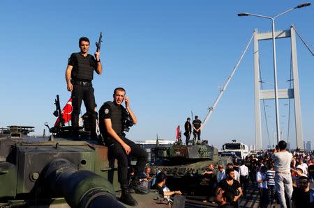 Policemen stand atop military armored vehicles after troops involved in the coup surrendered on the Bosphorus Bridge in Istanbul, Turkey July 16, 2016. REUTERS/Murad Sezer