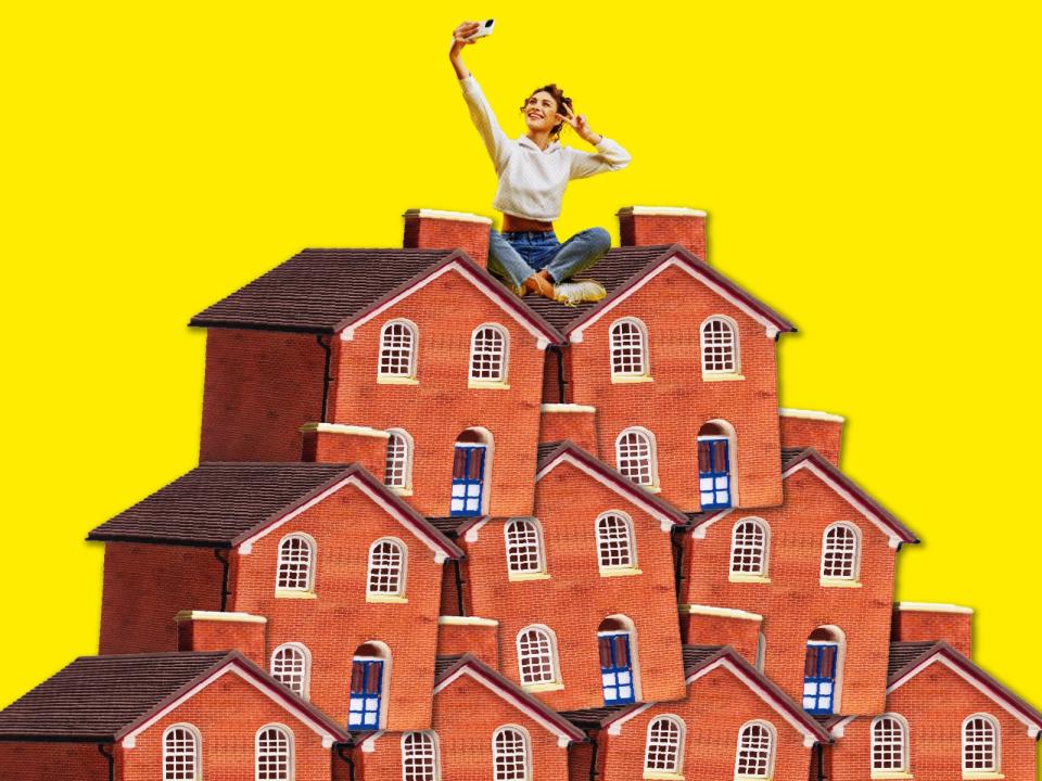 woman taking a selfie while sitting cross legged on a pile of houses