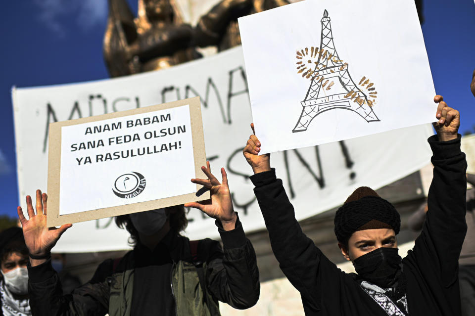 Protesters hold placards with a depiction of Eiffel Tower in Paris, right, marked with a shoe stamp a sign of disrespect, and one, left with a slogan reading in Turkish: "May my mother and father be sacrificed in your name, Prophet!", during a protest by members of Islamic groups against France in Istanbul, Sunday, Nov. 1, 2020. There had been tension between France and Turkey after Turkish President Recep Tayyip Erdogan said France's President Emmanuel Macron needed mental health treatment and made other comments that the French government described as unacceptably rude. Erdogan questioned his French counterpart's mental condition while criticizing Macron's attitude toward Islam and Muslims. (AP Photo)