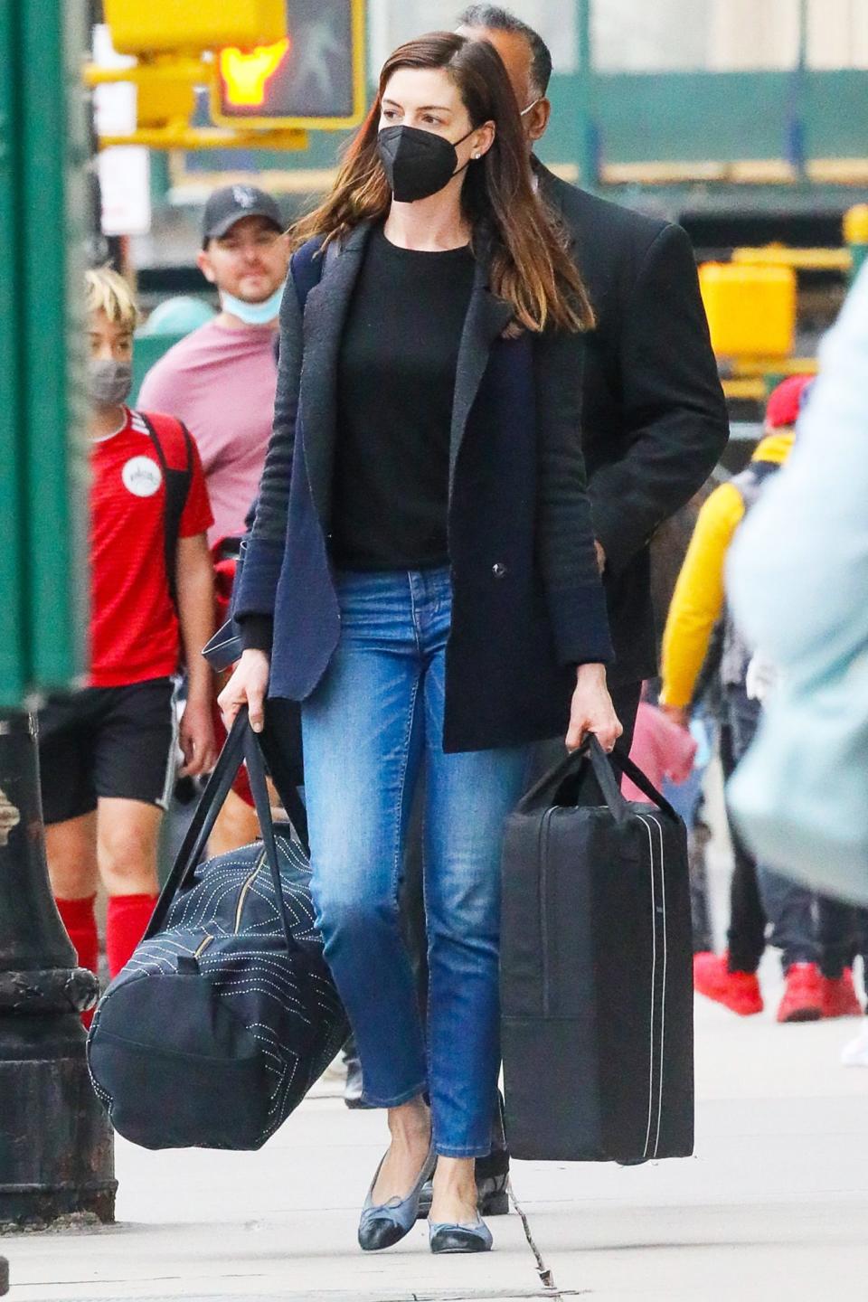 <p>Anne Hathaway carries luggage to her car as husband Adam Shulman waits to driver her on Sunday in N.Y.C.</p>