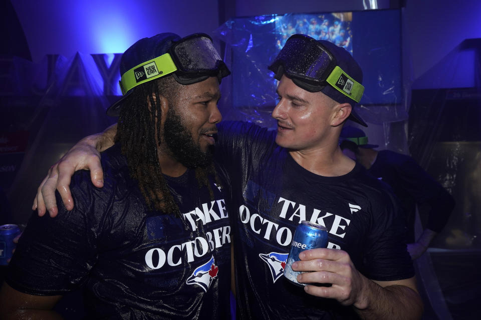 Toronto Blue Jays' Vladimir Guerrero Jr., left, celebrates with teammates in the locker room after clinching a berth in the AL wild card series following a baseball game against the Tampa Bay Rays in Toronto, Sunday, Oct. 1, 2023. (Frank Gunn/The Canadian Press via AP)