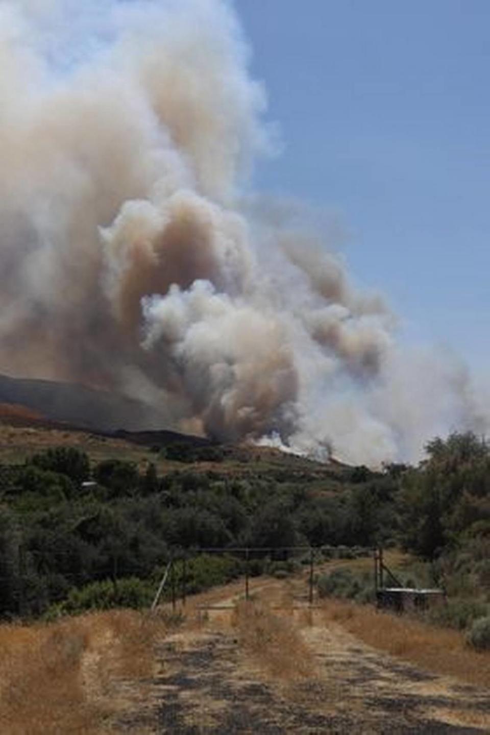 A column of smoke rises from a wildfire between Benton City and Prosser