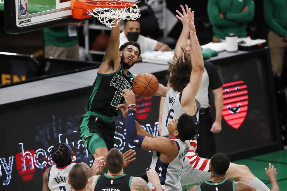 Boston Celtics' Jayson Tatum (0) dunks against Washington Wizards' Robin Lopez (15) during the first half of an NBA basketball game, Sunday, Feb. 28, 2021, in Boston. (AP Photo/Michael Dwyer)