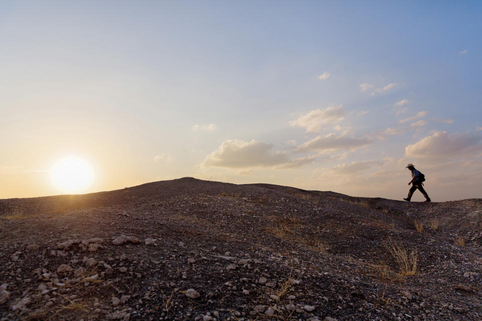 In this photo taken Thursday, Jan. 10, 2013 and released by the National Geographic Society on Wednesday, Nov. 20, 2013, journalist Paul Salopek walks across the Afar desert of Ethiopia as part of his planned seven-year global trek from Africa to Tierra del Fuego. In Paul Salopek's first year of his trek across the globe, the reporter walked alongside his camels for days in Ethiopia without seeing glass or bricks or any other signs of modern humanity, ate a hamburger on a U.S. military base, was shadowed by minders in the Saudi desert – and now has only 20,000 miles (32,000 kilometers) to go. (AP Photo/National Geographic Society, John Stanmeyer) NO SALES, ONE-TIME USE ONLY, NO ARCHIVING