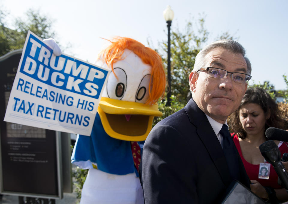 Rep. David Schweikert (R-Ariz.) speaks with reporters as he leaves the House Republican Conference meeting with GOP nominee for Vice President Mike Pence at the Capitol Hill Club as a man in a duck costume stands behind him on Sept. 13, 2016. The unidentified man in the costume holds a sign calling on Donald Trump to release his tax returns.