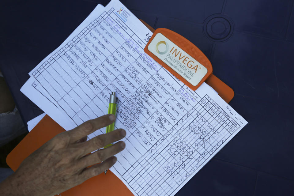 In this Feb. 19. 2019 photo, a clipboard shows the names of the persons who signed up to volunteer to help bring humanitarian, during a meeting to recruit volunteers, at a square in Caracas, Venezuela. So far, more than 800,000 volunteers have signed up to help through a designated website, organizers say. (AP Photo/Fernando Llano)