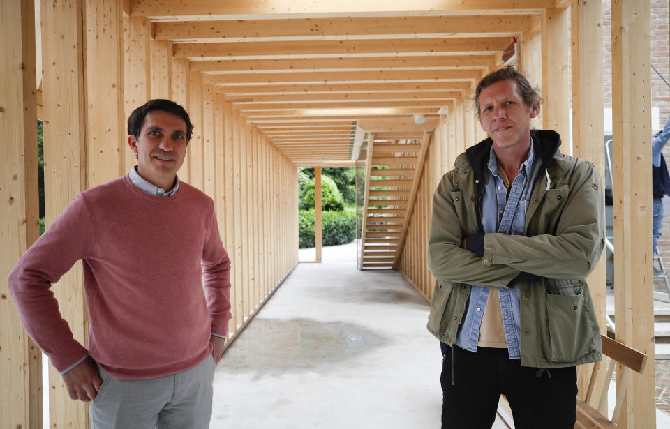 Paul Preissner, left, and Paul Anderson, creators of the installation "American Framing", pose for a photo at the United States Pavilion during a preview for the press, at the Biennale International Architecture exhibition, in Venice, Italy, Wednesday, May 19, 2021. The 17th International Architecture Exhibition opens Saturday after a one-year pandemic delay, during which time architecture has emerged as one of the key disciplines in the global coronavirus response. (AP Photo/Alessandra Tarantino)