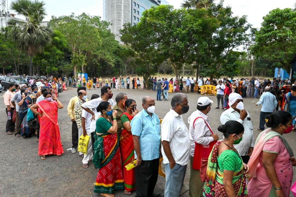 People wait in queues to receive the vaccine at a vaccination centre in Mumbai 21 April