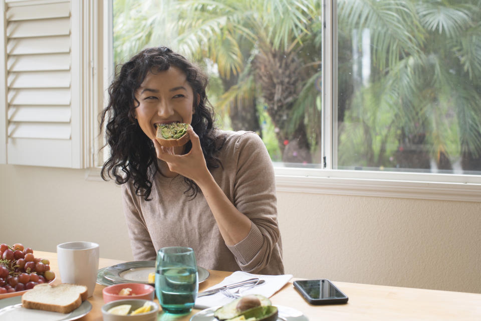 woman eating avocado on toast