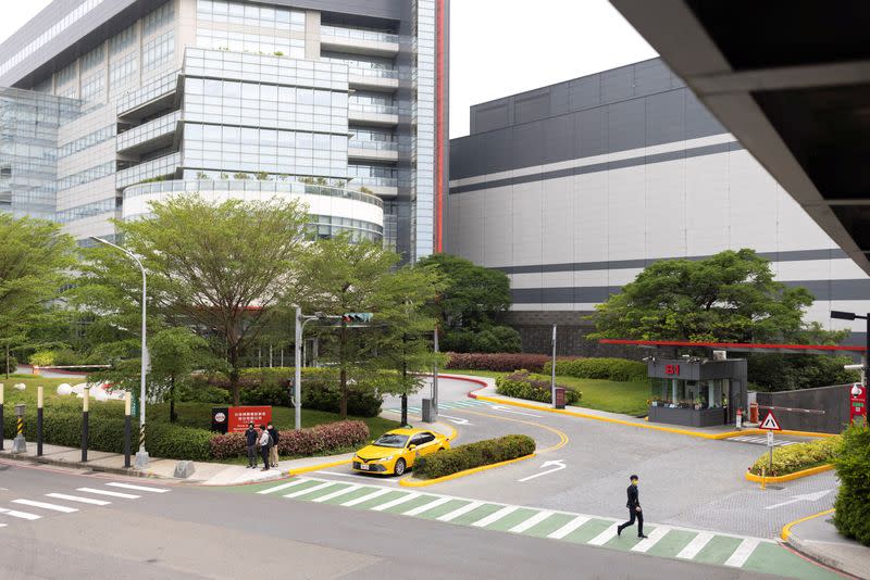 A man walks past an entrance of a Taiwan Semiconductor Manufacturing Co Ltd (TSMC) factory in Hsinchu