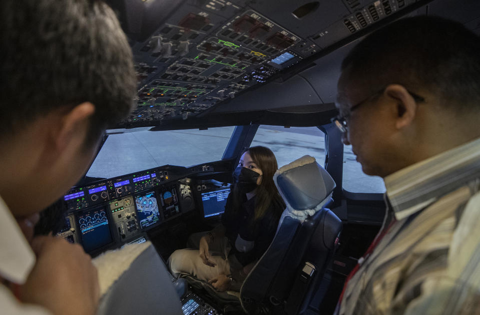 A customer sits in a Boeing A380 flight simulator for a flight experience at the Thai Airways head office in Bangkok, Thailand on Oct. 3, 2020. The airline is selling time on its flight simulators to wannabe pilots while its catering division is serving meals in a flight-themed restaurant complete with airline seats and attentive cabin crew. The airline is trying to boost staff morale, polish its image and bring in a few pennies, even as it juggles preparing to resume international flights while devising a business reorganization plan. (AP Photo/Sakchai Lalit)