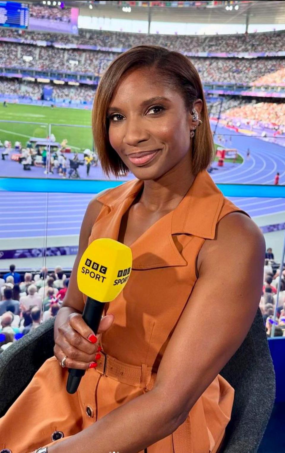 Dame Denise Lewis stays true to her personal style in this rust orange belted dress by Karen Millen