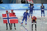 Team Norway, with Sverre Lunde Pedersen left, Hallgeir Engebraaten and Peder Kongshaug, right, celebrates in front of Team Russian Olympic Committee after after they won the gold medal in the speedskating men's team pursuit finals at the 2022 Winter Olympics, Tuesday, Feb. 15, 2022, in Beijing. (AP Photo/Ashley Landis)