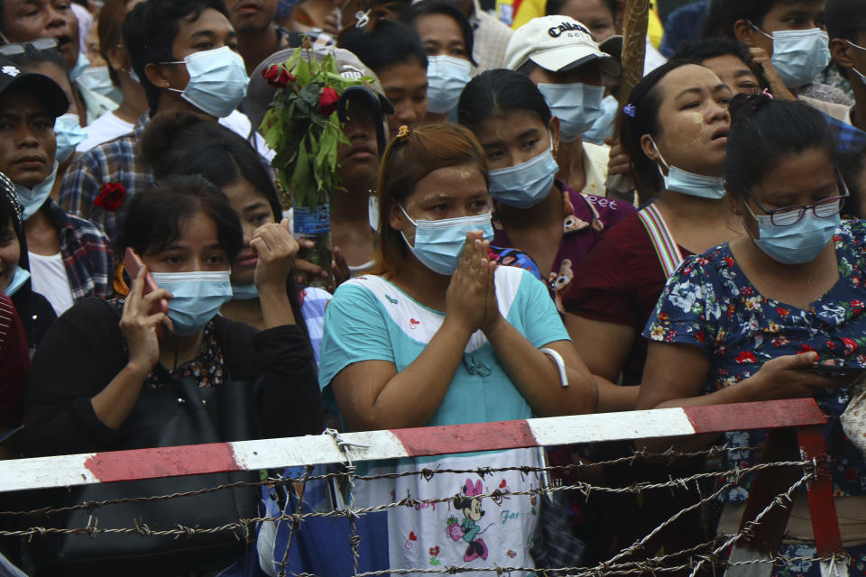 A woman gestures with her hands together while waiting with large crowds outside Insein Prison in Yangon, Myanmar, Wednesday, June 30, 2021. Myanmar's government began releasing about 2,300 prisoners on Wednesday, including activists who were detained for protesting against the military's seizure of power in February and journalists who reported on the protests, officials said. (AP Photo)