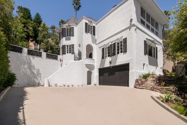 Perched in Los Feliz, the historic home presents a handsome white-and-black facade. Parking is no issue here, thanks to the property's two-car garage and wide driveway.