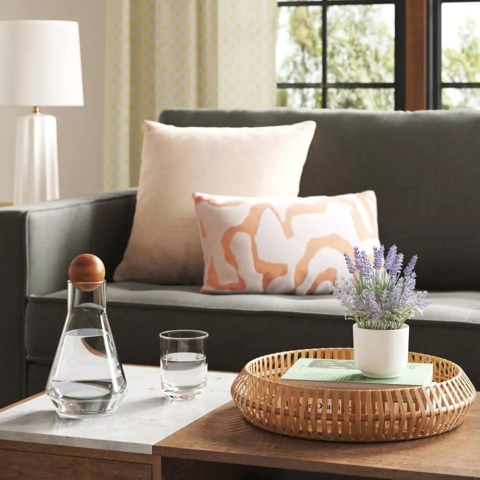 The faux lavender plant in a white pot on a table