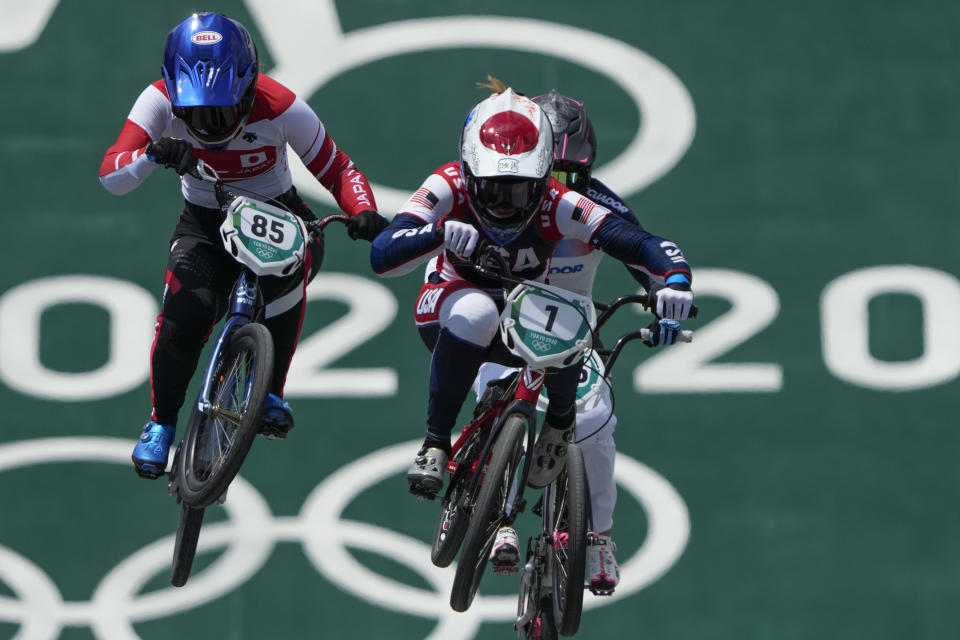 Alise Willoughby of the United States, center, and Sae Hatakeyama of Japan, left, compete in the women's BMX Racing quarterfinals at the 2020 Summer Olympics, Thursday, July 29, 2021, in Tokyo, Japan. (AP Photo/Ben Curtis)