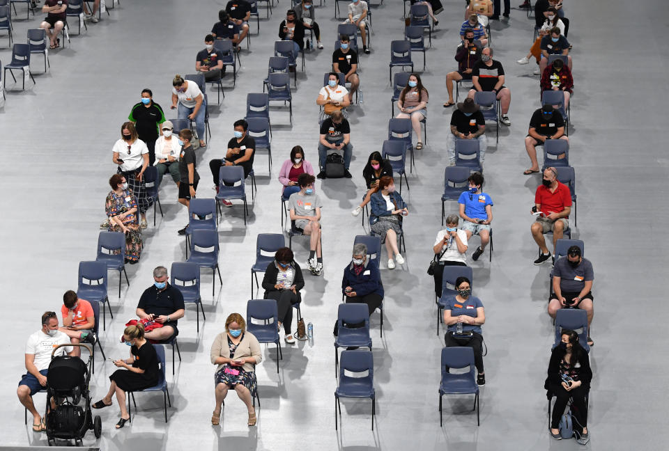 People are seen in the post vaccination observation area after receiving their COVID-19 vaccination at the Boondall mass vaccination hub in Brisbane, Saturday, September 18, 2021.