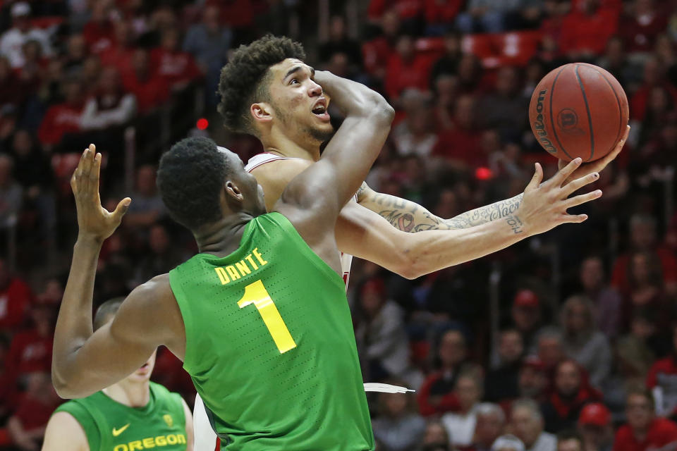 Utah forward Timmy Allen, rear, is fouled by Oregon center N'Faly Dante (1) as he drives to the basket in the second half during an NCAA college basketball game Saturday, Jan. 4, 2020, in Salt Lake City. (AP Photo/Rick Bowmer)