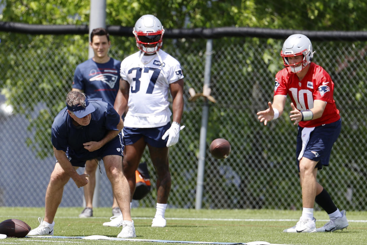 Patriots head coach Bill Belichick snaps the ball for quarterback Mac Jones during an OTA practice. (Photo by Fred Kfoury III/Icon Sportswire via Getty Images)