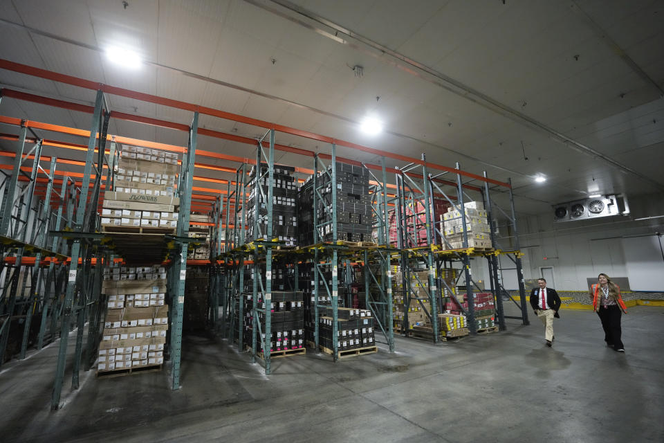 People walk past pallets of fresh flowers inside a refrigerated processing area which Avianca Cargo recently expanded to increase its capacity for handling imported flowers by over 80%, at Miami International Airport in Miami, Monday, Feb. 12, 2024. Roughly 90% of flowers imported to the U.S. pass through Miami's airport, most of them arriving from South American countries such as Colombia and Ecuador. (AP Photo/Rebecca Blackwell)