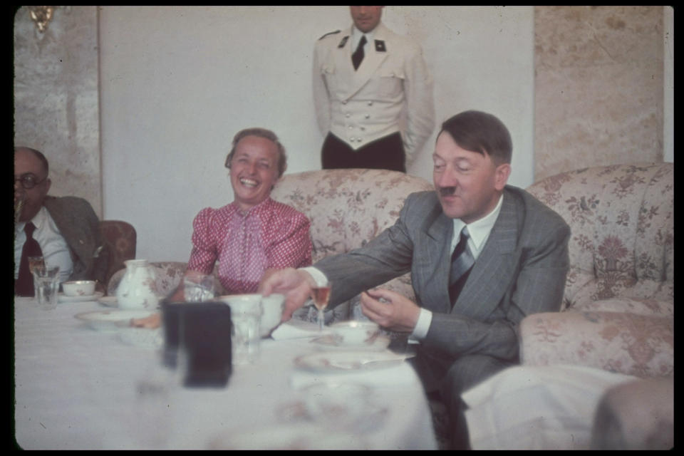 German Fuhrer and Reichskanzler Adolf Hitler (1889 - 1945) (right) eats a meal with his personal physician, Professor Theodor Morell (1886 - 1948) (left), and the wife of Gauleiter Albert Forster, at the Berghof (formerly known as Haus Wachenfeld), Hitler's estate in Berchtesgaden, Upper Bavaria, Germany, late 1930s. (Photo by Hugo Jaeger/Timepix/Time Life Pictures/Getty Images)