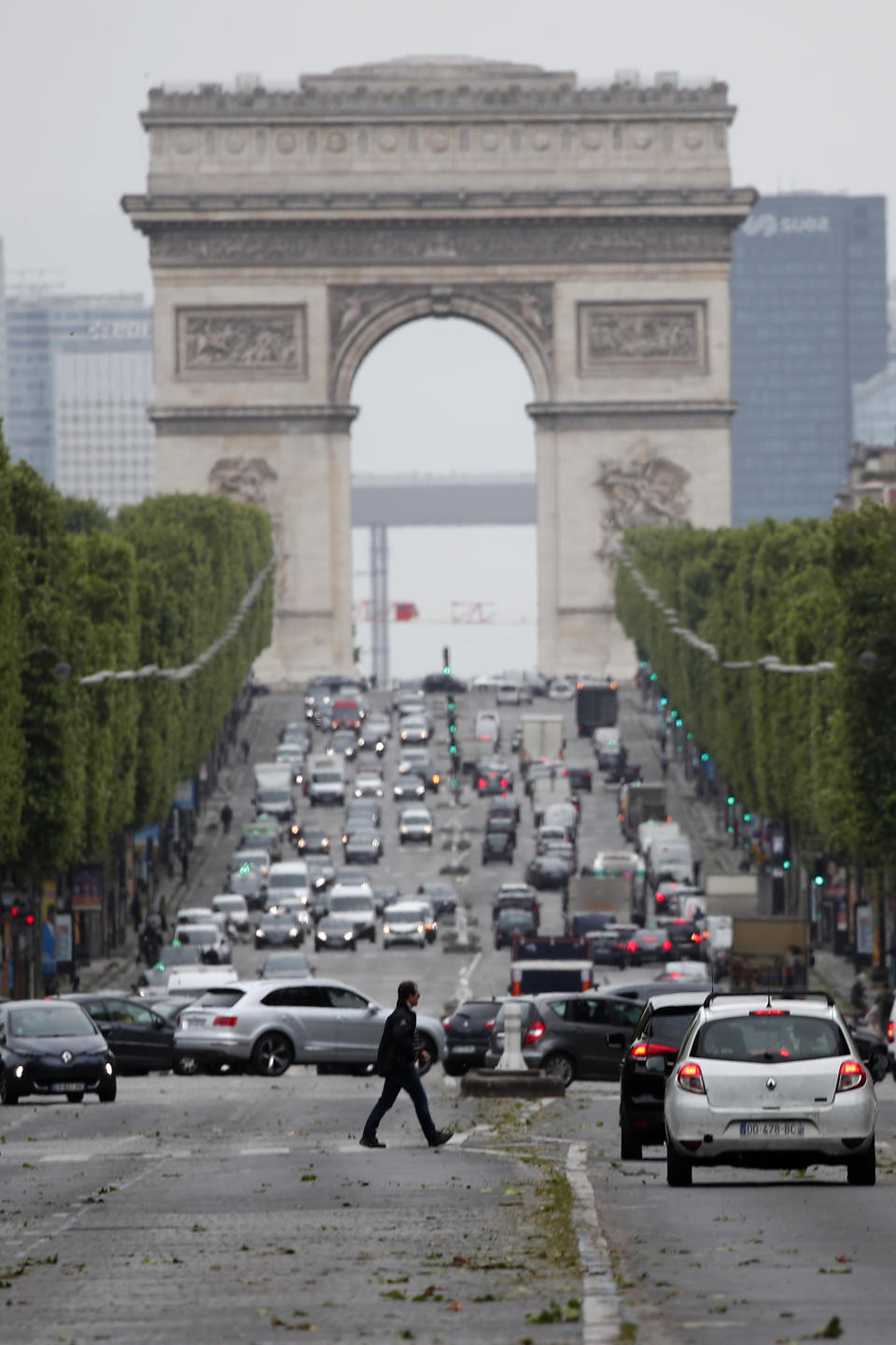 Cars drive on the Champs Elysee avenue, with Arc de Triomphe in background,, Monday, May 11, 2020 in Paris. he French began leaving their homes and apartments for the first time in two months without permission slips as the country cautiously lifted its lockdown. Clothing stores, coiffures and other businesses large and small were reopening on Monday _ with strict precautions to keep the coronavirus at bay. (AP Photo/Francois Mori)