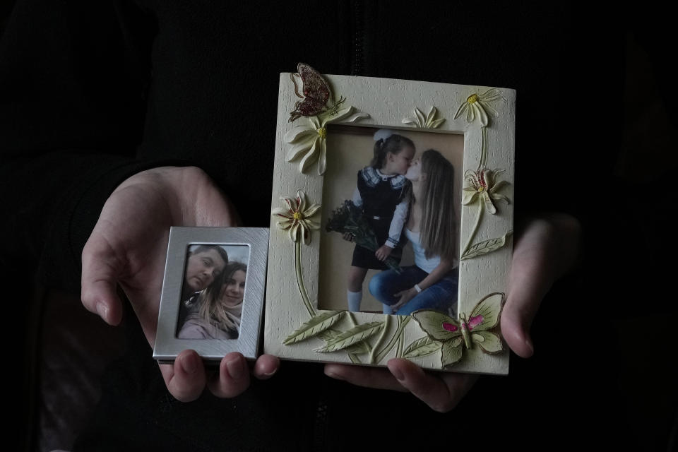 Viktoria Kovalenko shows pictures of herself with her husband and 12 year old daughter at her home in a village in Kent, Thursday, Feb. 9, 2023. Viktoria, 34, and her daughter Varvara are trying to settle in Britain after fleeing the war in Ukraine, where she lost her husband and 12-year-old daughter during a Russian military attack. The family have found housing through a charity, but they long to return to their own home in Ukraine. (AP Photo/Frank Augstein)