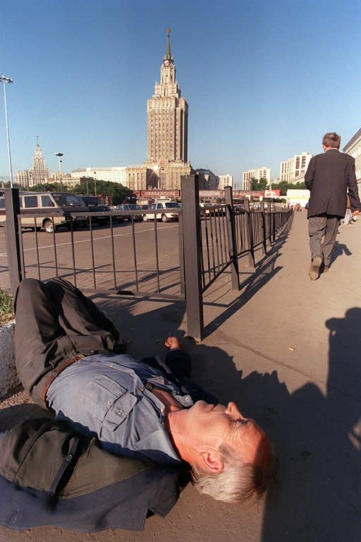 A drunken man sleeps on a street in Moscow. Some 2.5 million Russians are registered as addicted to alcohol, and almost one in two Russian men regularly abuse alcohol, an expert says