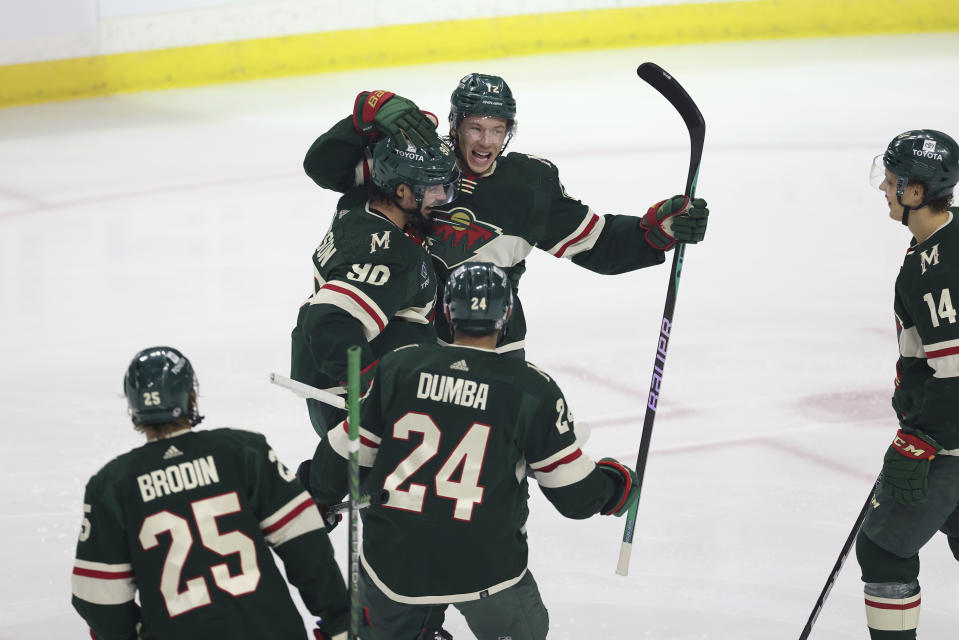 Minnesota Wild left wing Matt Boldy (12) celebrates with teammates after scoring a goal against the Washington Capitals during the first period of an NHL hockey game Sunday, March 19, 2023, in St. Paul, Minn. (AP Photo/Stacy Bengs)