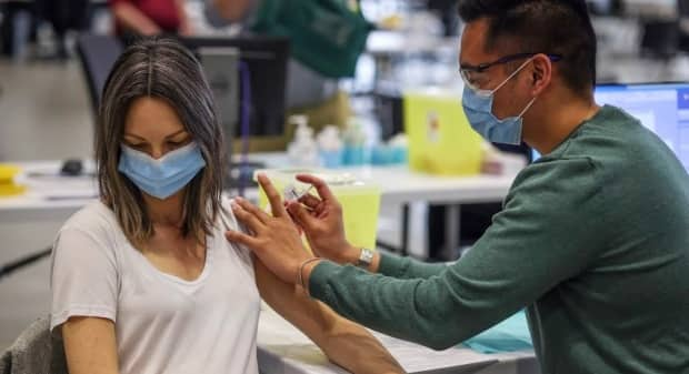 Kathryn Kazmerik, 32, receives her COVID-19 vaccine at the Telus Convention Centre mass-vaccination in Calgary on April 19, 2021. (Leah Hennel/AHS - image credit)