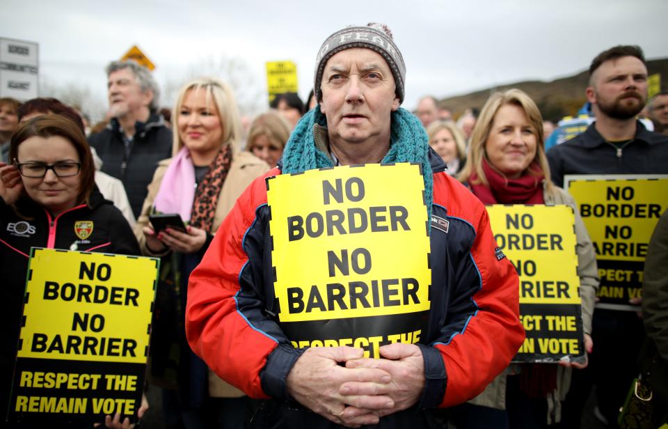 Protesters against any border between Ireland and Northern Ireland because of Brexit hold placards at the Carrickcarnan border between Newry in Norther Ireland and Dundalk in the Irish Republic on March 30, 2019. - British Prime Minister Theresa May on Saturday mulled a possible fourth attempt to get her Brexit agreement through parliament, faced with the growing risk of a chaotic no-deal exit in less than two weeks' time. Britain's exit from the European Union brings with it the fear of the possible reimposition of physical checks on the Irish border, which would be the UK's only land border with the EU, a fear especially real in a no-deal scenario. A so-called hard border could threaten the 1998 Good Friday Agreement that brought an end to decades of civil strife between Protestant supporters of British rule over the province, and Irish Catholic nationalists, who believe in a united Ireland. (Photo by Paul FAITH / AFP)        (Photo credit should read PAUL FAITH/AFP/Getty Images)