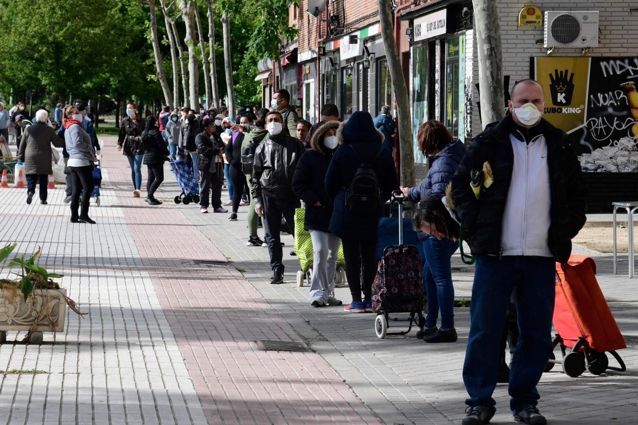 People queue to get a free food ration at a food bank in Madrid: AFP via Getty Images