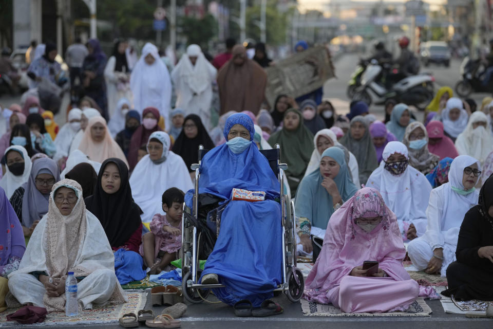 Muslim women attend a morning prayer marking the Eid al-Adha holiday on a street in Jakarta, Indonesia, Sunday, July 10, 2022. Muslims around the world will celebrate Eid al-Adha, or Festival of Sacrifice, slaughtering sheep, goats, cows and camels to commemorate Prophet Abraham's readiness to sacrifice his son Ismail on God's command. (AP Photo/Tatan Syuflana)