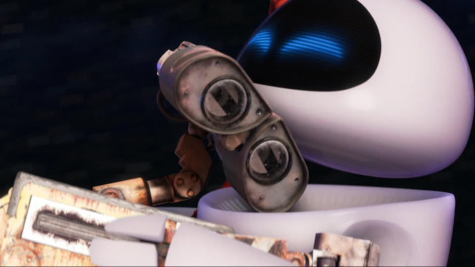 Wall-E and Eve float through space in an embrace.