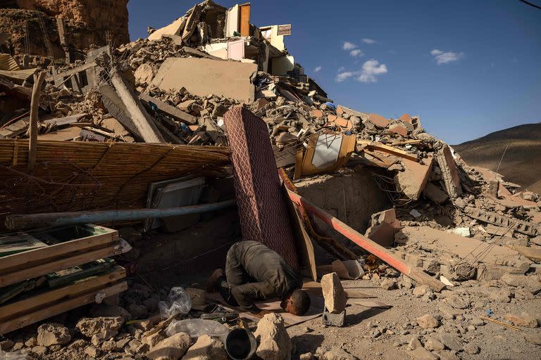 Un voluntario reza cerca de los escombros de los edificios derrumbados en la aldea de Imi N'Tala, cerca de Amizmiz, en el centro de Marruecos