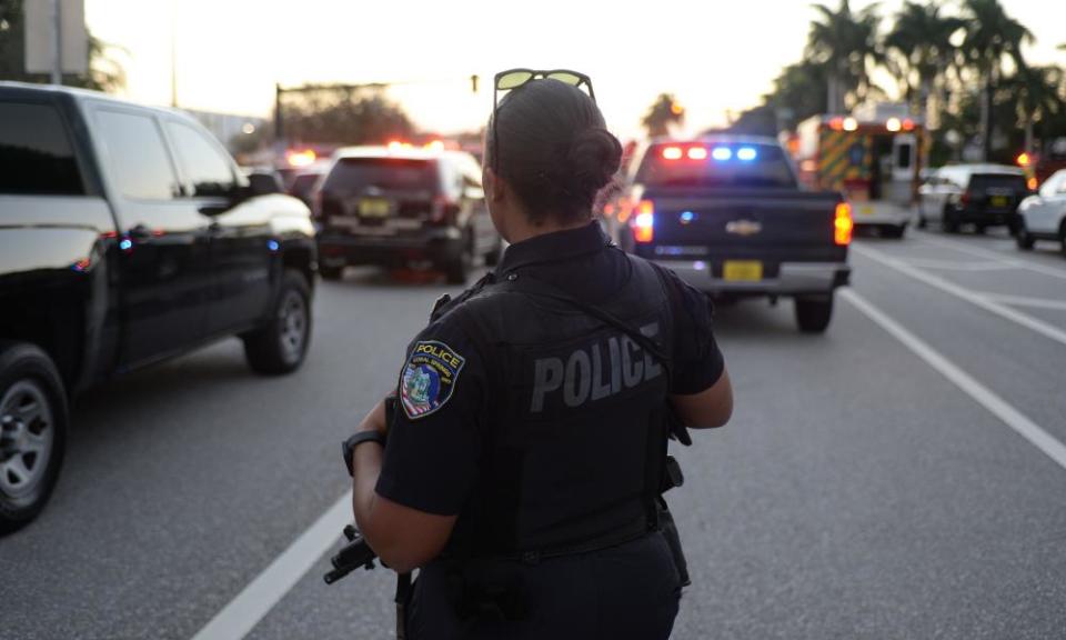 Police at the scene outside Marjory Stoneman Douglas high school in Parkland, Florida, where more than a dozen were killed. 