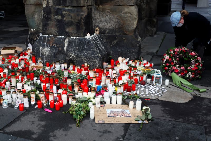 A person lays a wreath of flowers near the site where a car crashed into pedestrians in Trier