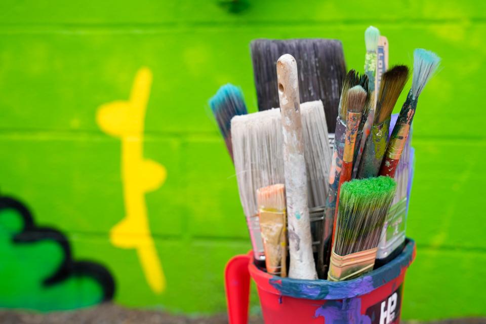 Elaina Workley's paintbrushes sit beside her mural in the alley of Lafayette Street, between Fourth Street and Grant Avenue, one of 35 murals that is to be displayed during the Alley Islands Street Festival on Saturday.