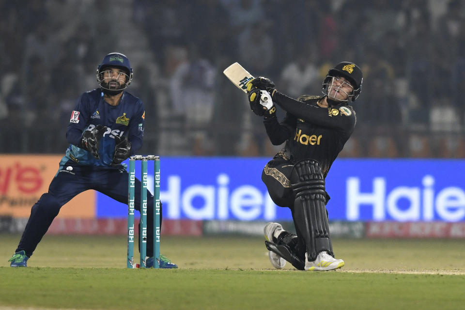 Peshawar Zalmi' Luke Wood, right, plays a shot for six as Multan Sultans' Mohammad Rizwan watches during the Pakistan Super League T20 cricket match between Multan Sultans and Peshawar Zalmi, in Multan, Pakistan Friday, Feb. 23, 2024. (AP Photo/M. Khan)